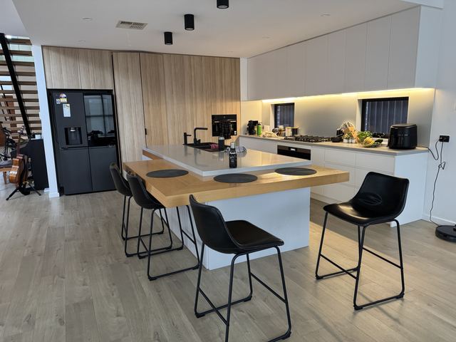 The house you visited: stone-top island with a lower oak table joined on.