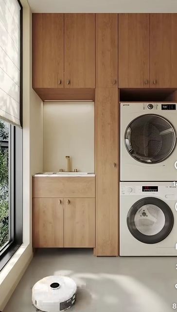 Laundry: washer and dryer stacked in an oak column, with a sink beside them.