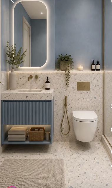 Bathroom: powder-blue walls, terrazzo, a fluted blue vanity and a backlit mirror.