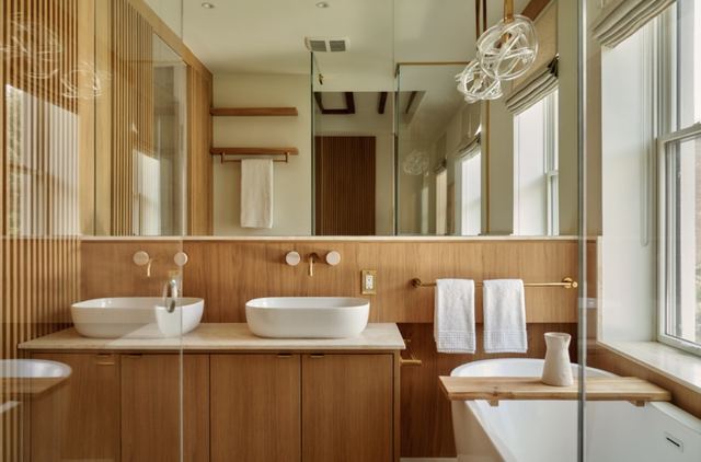 Bathroom: slatted oak wall, twin vessel basins, brass taps and a freestanding tub.