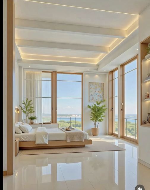 Bedroom: low oak bed, light coves between the beams, full-height garden glazing.