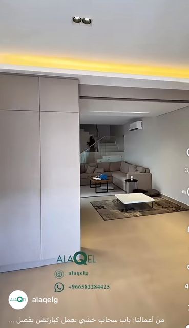 A storage wall of full-height handleless sliding doors, with a light cove along the ceiling.