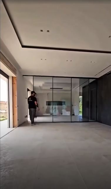 Full-height black-framed glass sliding doors across an open space.