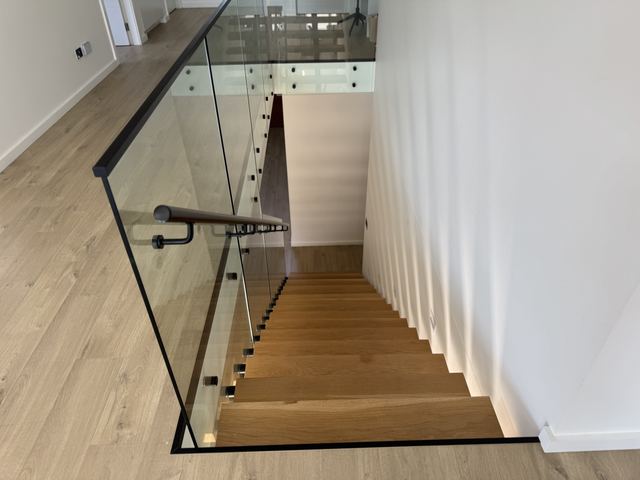 Your friends' stair from above: LED under each tread, a glass balustrade, a wood handrail.