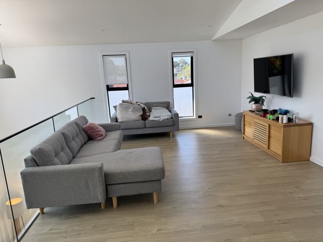 The same lounge: a grey sofa and an oak TV console.