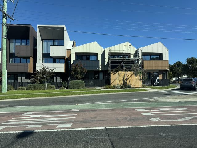 New townhouses: white and charcoal panels with timber accents.